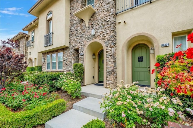 entrance to property with stone siding and stucco siding