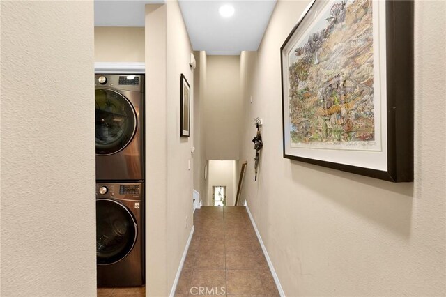 washroom with stacked washer / drying machine and tile patterned floors