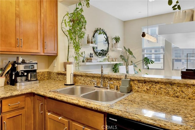 kitchen featuring black dishwasher, light stone counters, brown cabinets, and a sink