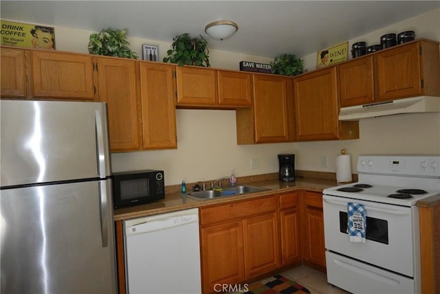 kitchen with light tile patterned flooring, white appliances, and sink