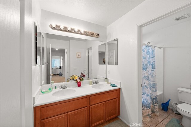 full bathroom with shower / bathtub combination with curtain, vanity, a textured ceiling, tile patterned flooring, and toilet