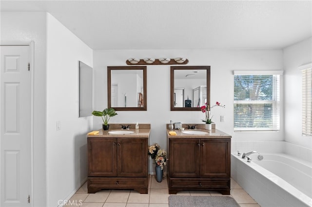 bathroom featuring vanity, a relaxing tiled tub, and tile patterned flooring