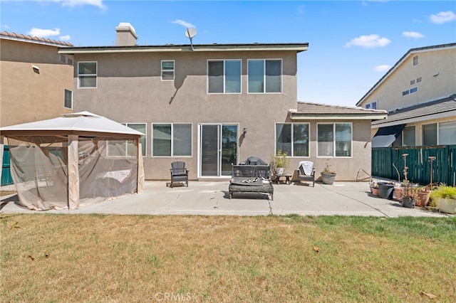 rear view of house with a lawn, a gazebo, and a patio area