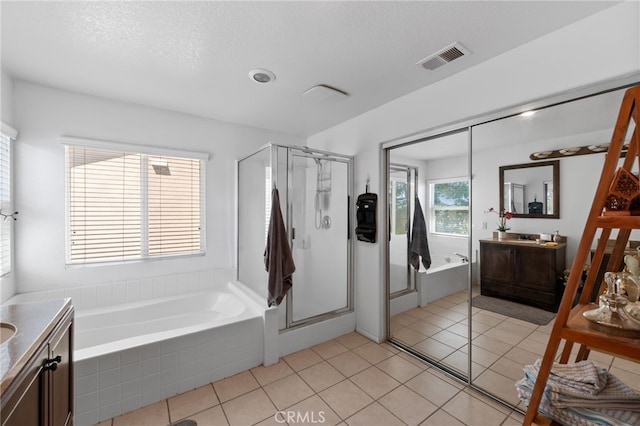 bathroom featuring plus walk in shower, tile patterned floors, a textured ceiling, and vanity