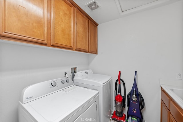 laundry room with washing machine and clothes dryer and cabinets