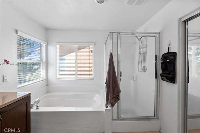 bathroom featuring vanity, separate shower and tub, and a textured ceiling