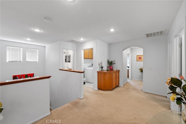 interior space featuring washer / clothes dryer and light carpet