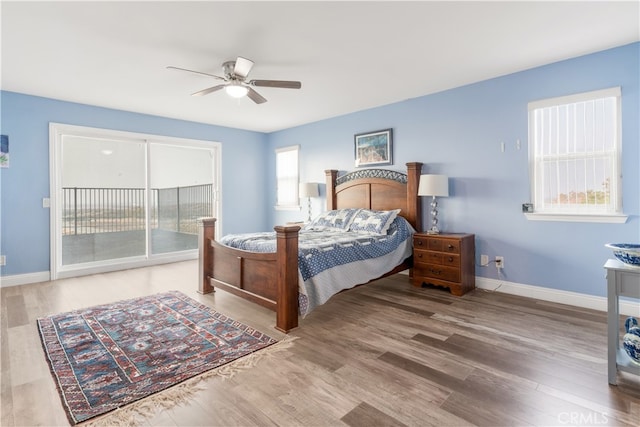 bedroom featuring access to exterior, wood-type flooring, and ceiling fan