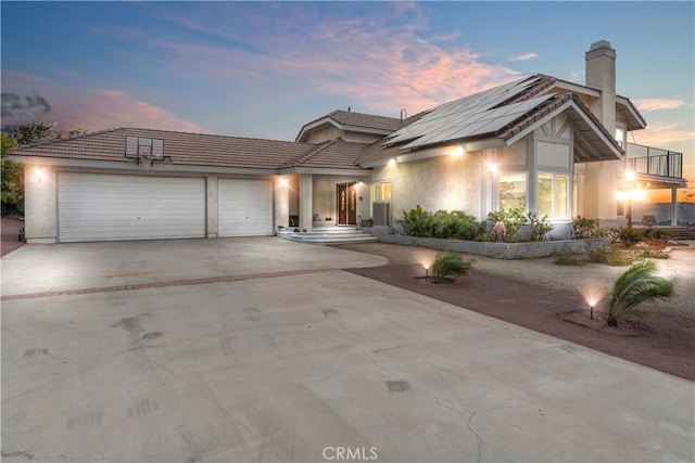 view of front of house featuring solar panels, central AC, and a garage