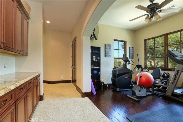 exercise room featuring recessed lighting, baseboards, arched walkways, a ceiling fan, and wood finished floors