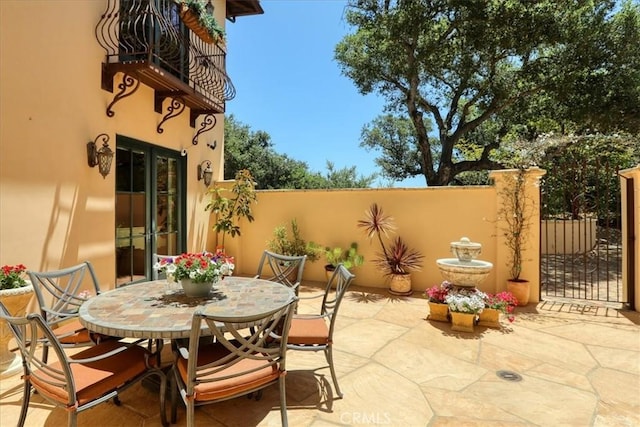 view of patio featuring fence, outdoor dining area, and french doors