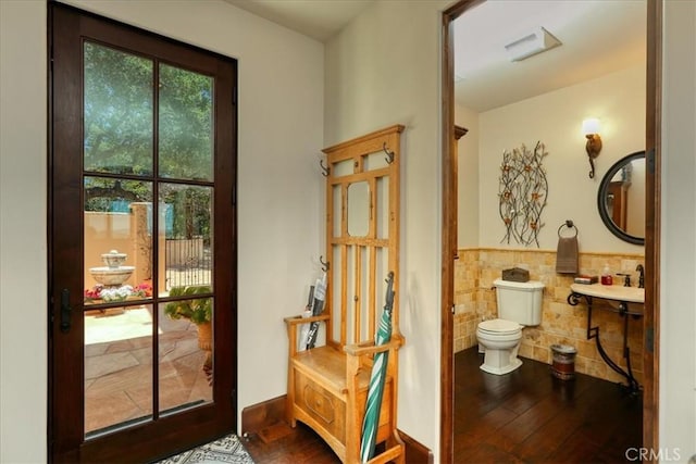 entryway featuring a wainscoted wall, tile walls, and wood finished floors