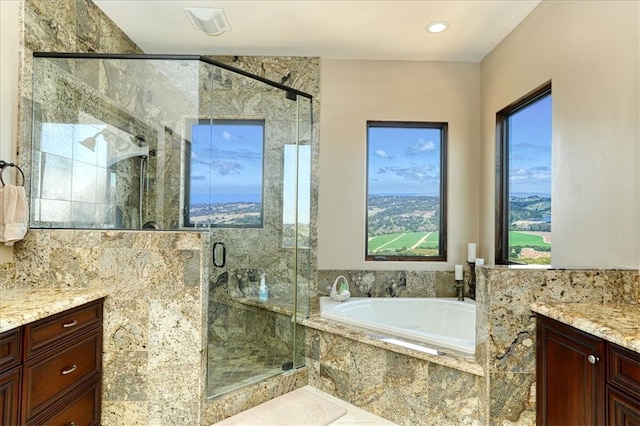 bathroom with a marble finish shower, a garden tub, and vanity