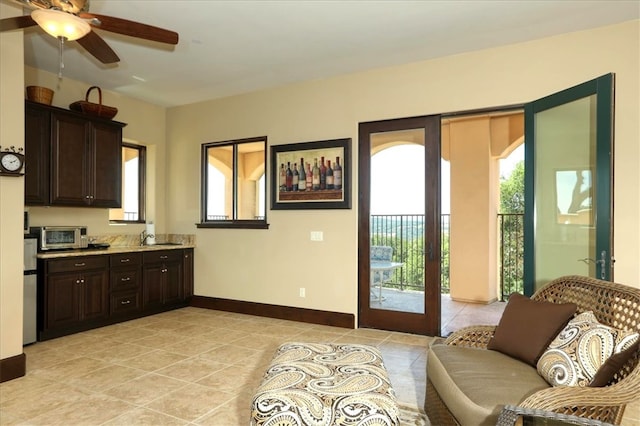 entryway with light tile patterned floors, a toaster, baseboards, and ceiling fan