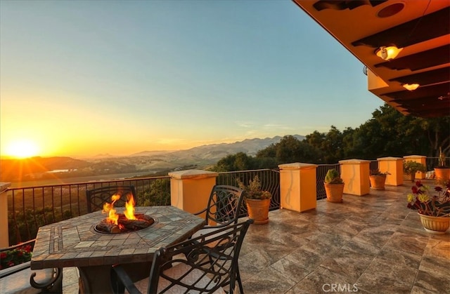 view of patio / terrace with a fire pit and a mountain view
