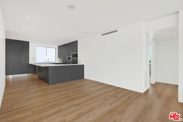 kitchen with light hardwood / wood-style flooring and a kitchen bar