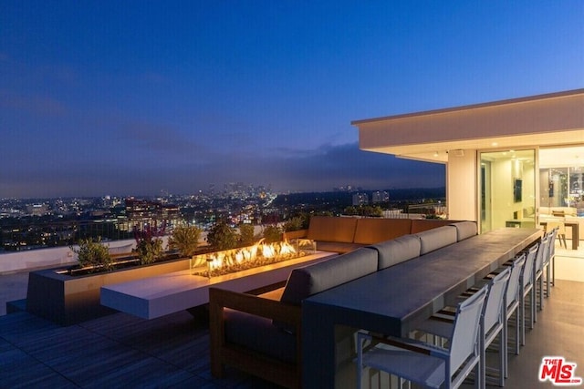 patio terrace at dusk featuring an outdoor living space with a fire pit