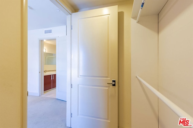 hallway with light colored carpet