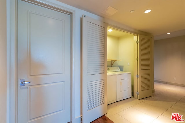 laundry room with washing machine and dryer and light tile patterned floors