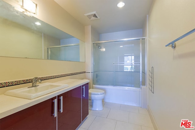 full bathroom featuring shower / bath combination with glass door, vanity, toilet, and tile patterned floors