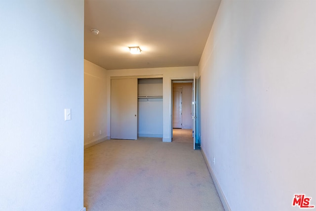 interior space with light carpet and a closet