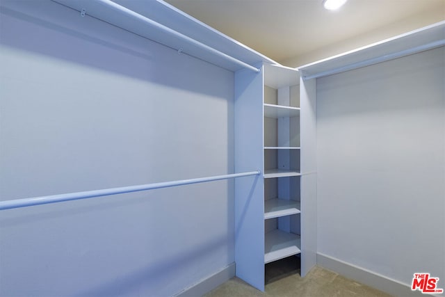 walk in closet featuring light carpet