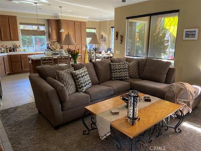 living room featuring light tile patterned flooring, ornamental molding, and sink