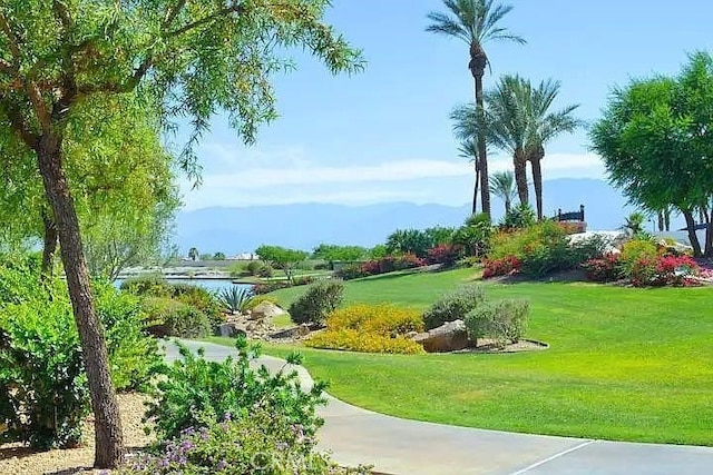 view of property's community featuring a yard and a water view