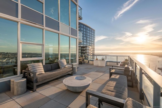 patio terrace at dusk with an outdoor living space and a balcony