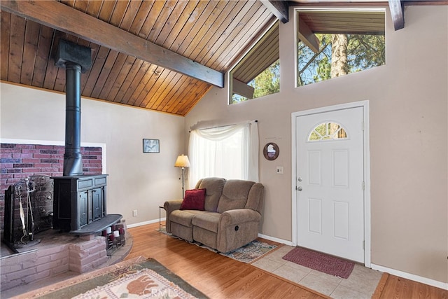 living room with wooden ceiling, lofted ceiling with beams, light hardwood / wood-style flooring, and a wood stove