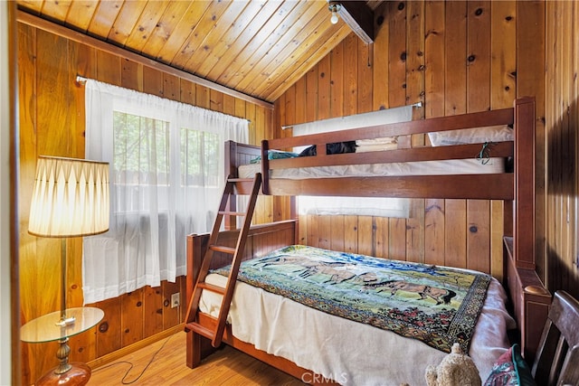 bedroom with wood-type flooring, vaulted ceiling, wood walls, and wooden ceiling