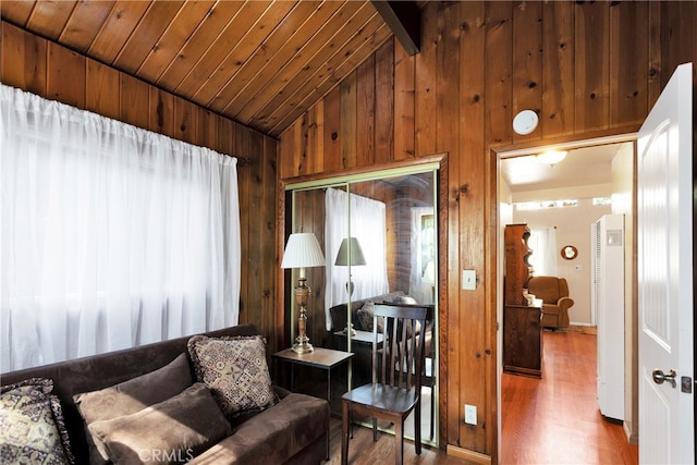 living room with hardwood / wood-style flooring, wood ceiling, wooden walls, and high vaulted ceiling