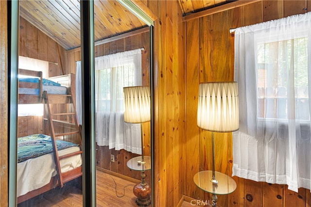 sitting room with hardwood / wood-style floors, wood ceiling, wood walls, and lofted ceiling