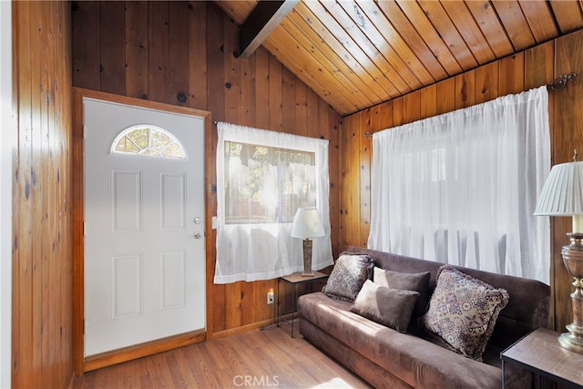 living room with vaulted ceiling with beams, wood-type flooring, wood ceiling, and wooden walls