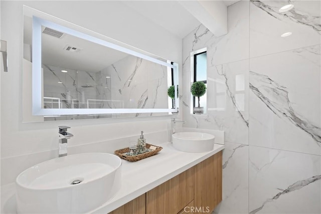 full bathroom with visible vents, a sink, and double vanity