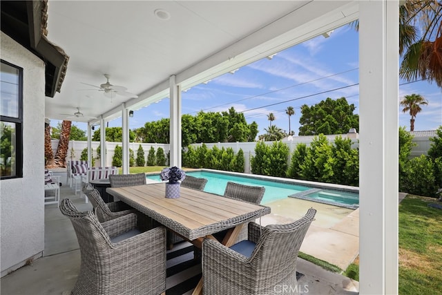 view of patio / terrace featuring ceiling fan, a pool with connected hot tub, a fenced backyard, and outdoor dining space