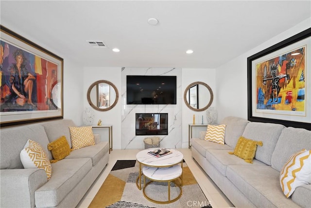 living room featuring a fireplace, visible vents, and recessed lighting