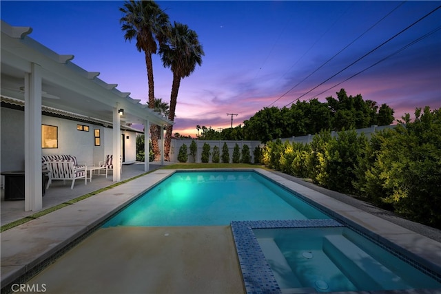 pool at dusk featuring a patio