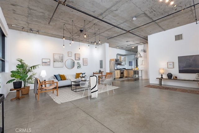 living room with electric panel, concrete floors, and track lighting