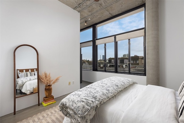 bedroom featuring track lighting and hardwood / wood-style flooring