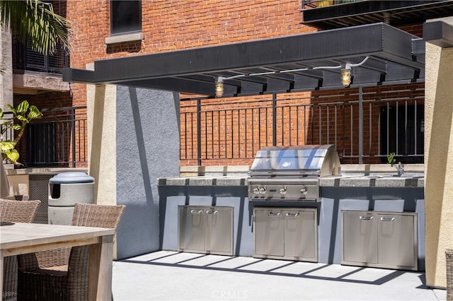 view of patio with sink, a pergola, grilling area, and exterior kitchen