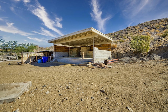 rear view of house with a mountain view and an outdoor structure