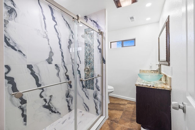 bathroom featuring a shower with door, vanity, and toilet