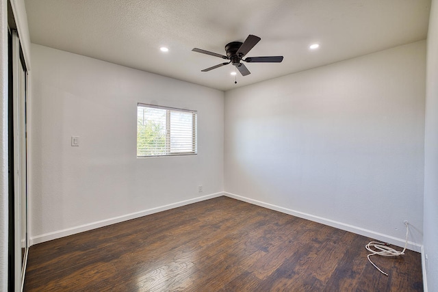 spare room with ceiling fan and dark wood-type flooring