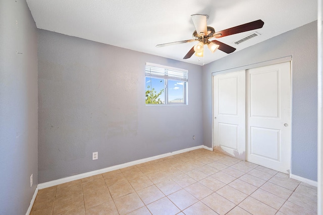 unfurnished bedroom featuring light tile patterned floors, a closet, vaulted ceiling, and ceiling fan