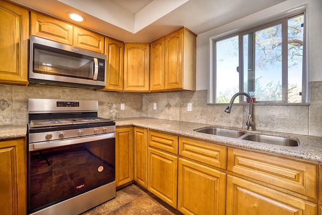 kitchen with decorative backsplash, sink, and appliances with stainless steel finishes