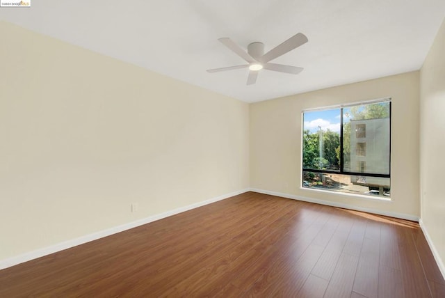 empty room with dark wood-type flooring and ceiling fan