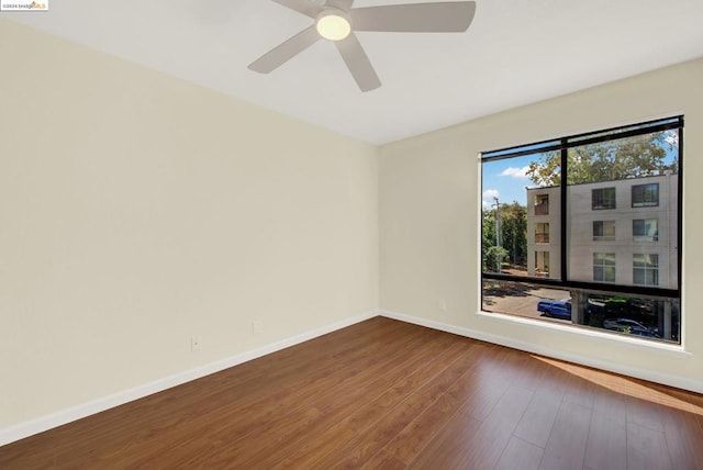 spare room with ceiling fan and dark wood-type flooring