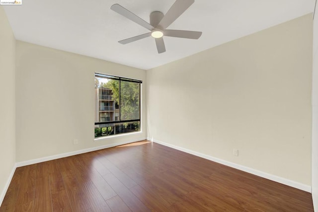 unfurnished room with ceiling fan and dark wood-type flooring