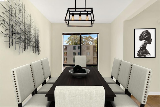 dining area featuring wood-type flooring and a chandelier